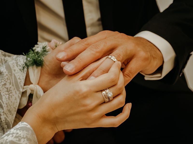 una pareja poniéndose los anillos de boda